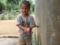 A boy in Quang Tri washing his hands with soap in a community cement tank