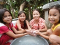 Vietnamese girls washing their hands in bowl of water